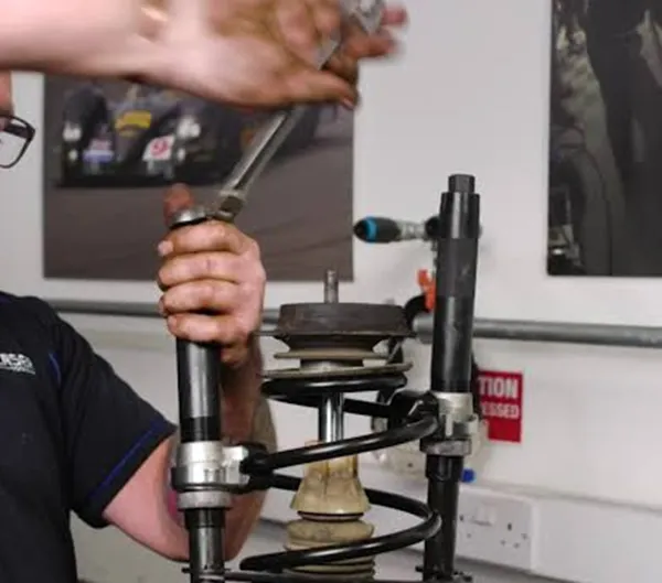 Safe Coil Spring Compression Before Removing Strut Mount Using a spring compressor safely during strut mount replacement