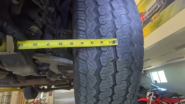 Laser alignment sensor mounted on a front wheel during toe measurement