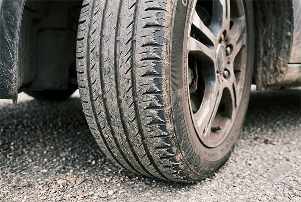 Close-up of tire shoulder feathering caused by toe misalignment